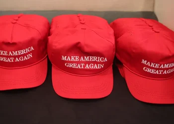 Houston Halloween display shows mannequins in red hats hanging from gallows with Mexican flag